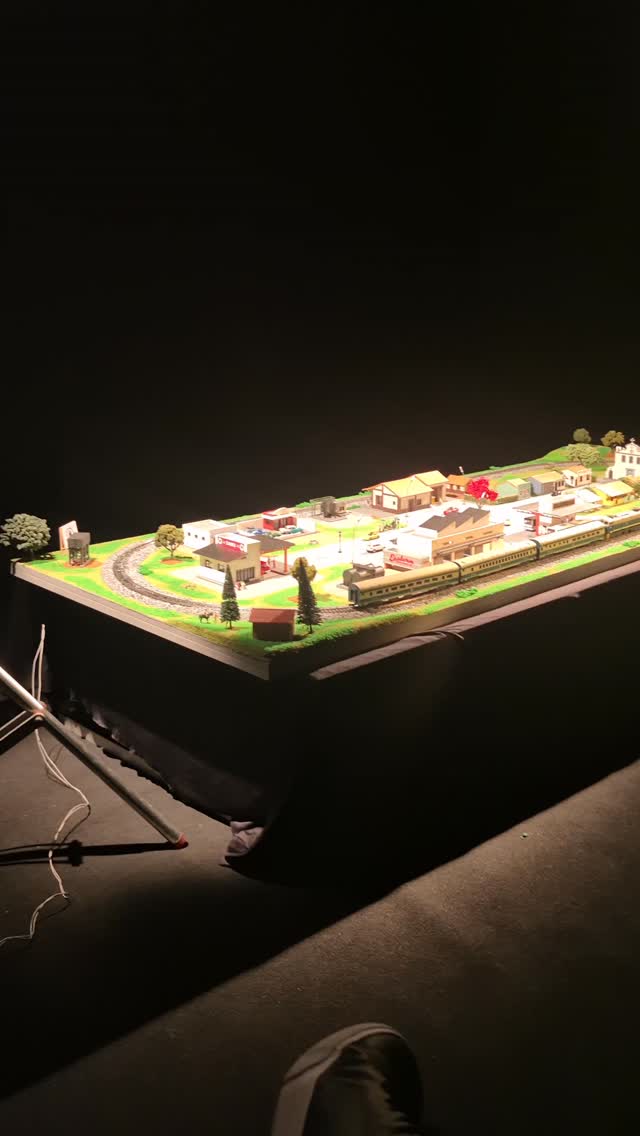 Cena em miniatura com estação e composição ferroviária