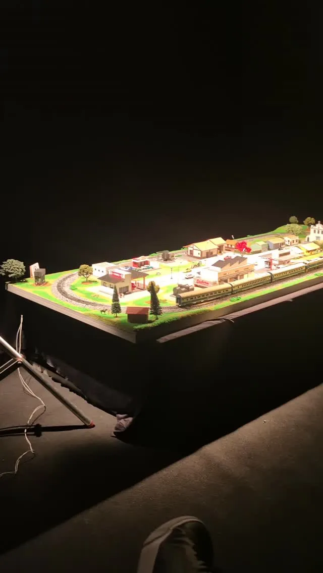 Cena em miniatura com estação e composição ferroviária